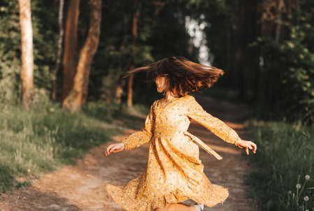 Portrait of a beautiful little girl among white dandelionsの写真素材