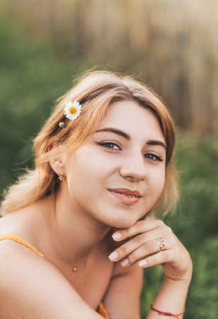 Young beautiful girl with a straw bag in a wheat fieldの写真素材