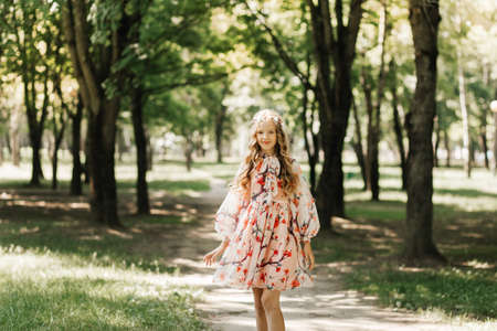 Little girl with long white hair and a bouquet of wildflowers in the parkの写真素材