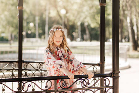 A little beautiful girl walks in a city park and dreamsの写真素材