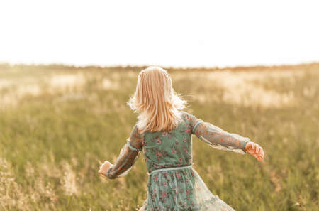 Positive charming little girl enjoying summer sunny day, expression emotions, having fun, happy child walking in summer dayの写真素材