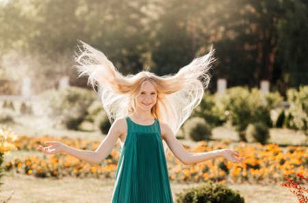 Beautiful teenage girl walking in the park in the summerの写真素材