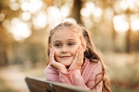 Portrait of a little girl on the background of the autumn park.の写真素材