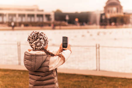 pretty little girl resting in autumnal parkの写真素材