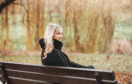 Autumn woman in autumn park. Warm sunny weather. Fall conceptの写真素材