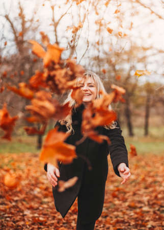 Autumn woman in autumn park. Warm sunny weather. Fall conceptの写真素材