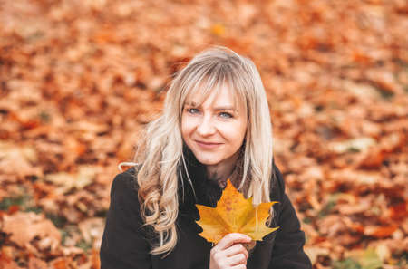Autumn woman in autumn park. Warm sunny weather. Fall conceptの写真素材