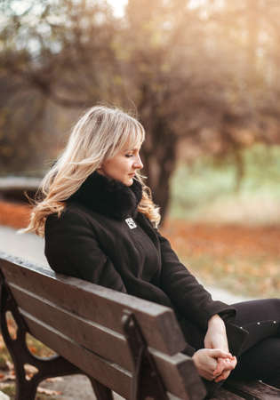 Autumn woman in autumn park. Warm sunny weather. Fall conceptの写真素材