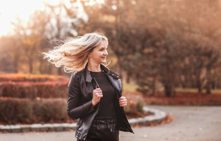 Autumn woman in autumn park. Warm sunny weather. Fall conceptの写真素材