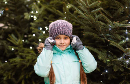 happy little girl at christmas market in winter evening.の写真素材