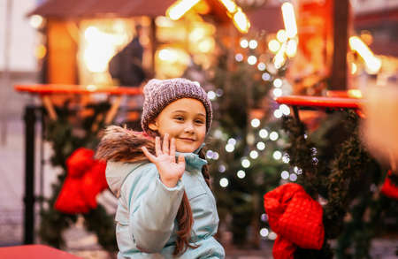 happy little girl at christmas market in winter evening.の写真素材