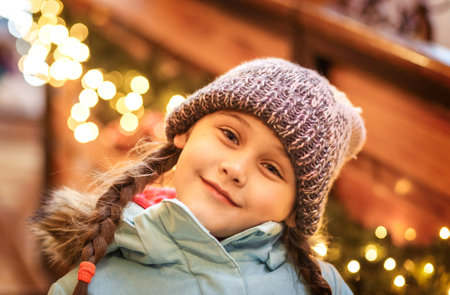happy little girl at christmas market in winter evening.の写真素材