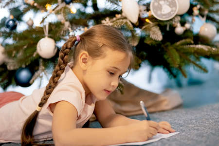Beautiful child girl near a Christmas tree. Christmas concept.