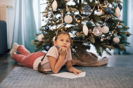 Beautiful child girl near a Christmas tree. Christmas concept.