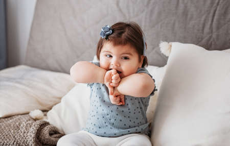 little child girl sit on sofa, happy emotion and face expression, blu tonedの写真素材