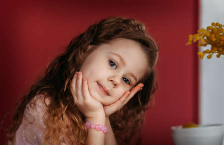 Close up cute little girl in bedroom, stay at home alone, upset child waiting for parentsの写真素材