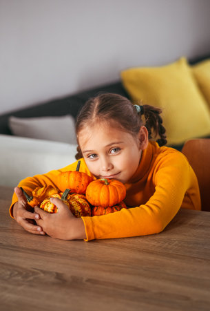 Little Girl Playing With a Pumpkin. emotional portrait at home. Halloween party concept.の写真素材