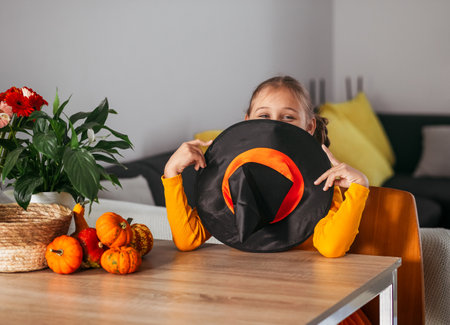 Little Girl Playing With a Pumpkin. emotional portrait at home. Halloween party concept.の写真素材