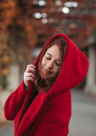 elegant young woman in a burgundy casual coat in autumn. Cute model walks in the park in golden autumn through colorful trees and fallen leaves. Autumn walk, colorful natureの写真素材