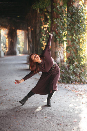 young smiling attractive woman in morning sunrise dancing in dress, healthy lifestyle, having funの写真素材