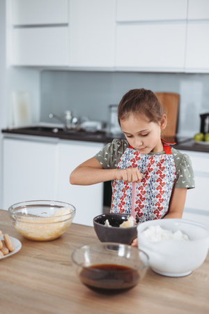 tiramisu making process in the kitchen- little girl making Italian desert with cocoa and espresso-dipped ladyfingers with mascarpone cream (step by step)の写真素材