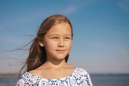 Close up Portrait of Happy Cute Girl during Summer Vacation On Exotic Tropical Beach. Wind in a hair. Family Journeyの写真素材