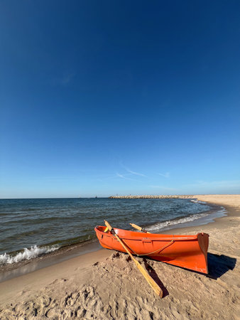 A lonely boat with oars stands on the seashore. Beautiful seascape. Relaxation and relaxation by the waterの写真素材