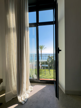 A view from a hotel room of the seashore with palm trees and waves. Relaxation and relaxation by the...