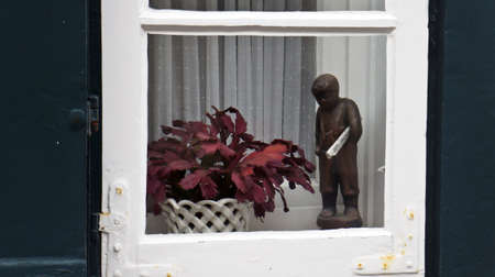 Lubeck, Germany - 07/26/2015 - Beautiful window with figure of man and flower in the pot, street of old townのeditorial素材