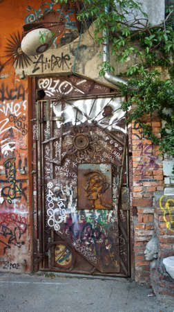Ljubljana, Slovenia - 07 19 2015 - Art door in Metelkova, artistic district with colored buildings, graffitti, sculptures and mosaics, sunny dayのeditorial素材