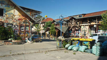 Ljubljana, Slovenia - 07 19 2015 - View of Metelkova in city center, artistic district with colored buildings, graffitti, sculptures and mosaics, sunny dayのeditorial素材