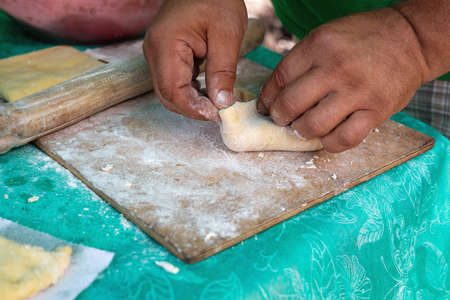 Man preparing dough for baking pie, patty closeup outdoors, cook on camp. Concept of homemade...