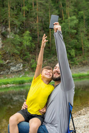 smiling man and young boy playing outdoors.