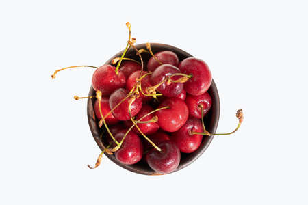 Cherries with stalks. Cherry in bowl isolated on white background. Top view