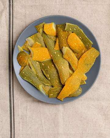 background of peeled zucchini or pumpkin in plate on tableの写真素材