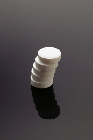 tower of medicinal pills on gray background with shadow. Health concept