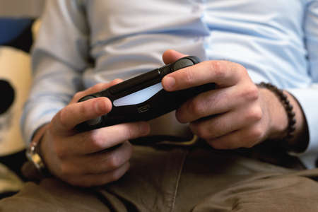 Gaming adult man holding simulator joypad. Gamer play game with gamepad controller. Front viewの写真素材