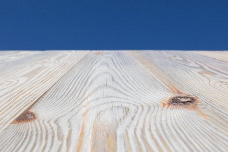 Wood table top on blue bright summer sky background with space for text