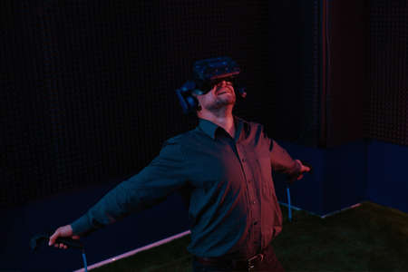 Man in vr headset glasses watching 3d film and enjoy new experience of being in cyberspace in virtual reality clubの写真素材