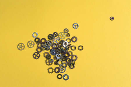 gears of different sizes lying on yellow background, top view. Development and solutions concept.の写真素材