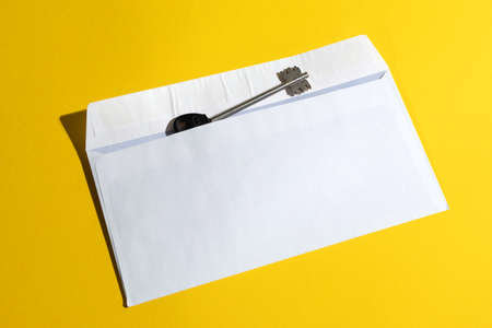 key in open mail envelop on yellow background. concept of solution, success, opportunity.