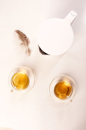 two mugs of herbal tea and teapot on white background. Top view. Concept of good morning, easy start to dayの写真素材