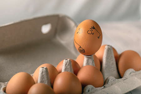 One pained egg standing apart from others eggs. concept of racism, intolerance, denial of society.の写真素材