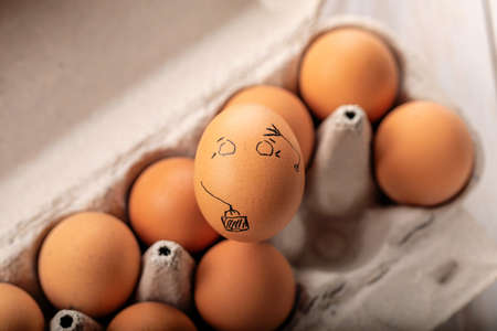 One egg stands out from crowd of other eggs. Concept of rejection, hostility, exclusion, exile.