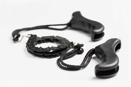 Black portable hand chain saw on white background. Black and white composition. Tool for cutting...