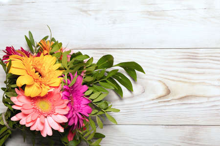 Beautiful romantic image of bouquet of multi colored gerbera flowers on wooden background. Flower arrangement of postcards, posters, interior paintings, stickers. Birthday gift or pleasant memory.の写真素材