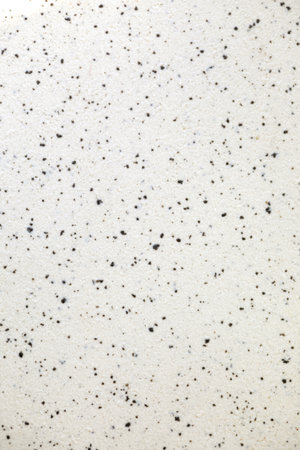 white stone marbled background with small black dots. Smooth and marble texture.
