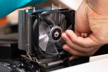 Close up of male hand installing cooler on computer processor. PC assembly and modernization. Person collecting professional PC for cryptocurrency mining. Russia, 17.08.2021のeditorial素材