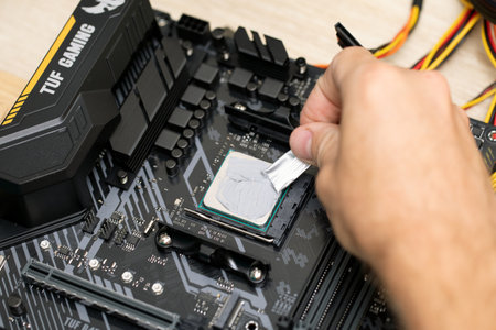 Man apply thermal paste for installing microprocessor on Tuf Gaming b450 plus motherboard. Maintenance computer cpu hardware. Russia, 17.08.2021のeditorial素材