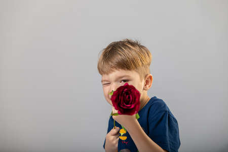 boy holds rose flower like a gun. copy spaceの写真素材
